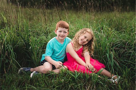 simsearch:649-09035543,k - Portrait of girl and brother sitting in field Fotografie stock - Premium Royalty-Free, Codice: 649-09035534