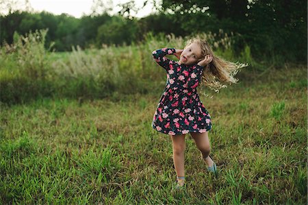 Blond haired girl running and pulling a face in field Fotografie stock - Premium Royalty-Free, Codice: 649-09035535