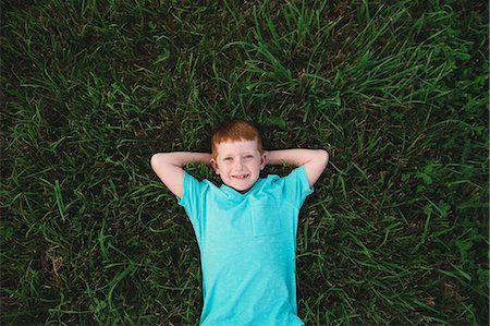 simsearch:614-08982787,k - Overhead portrait of red haired boy lying on grass Photographie de stock - Premium Libres de Droits, Code: 649-09035539