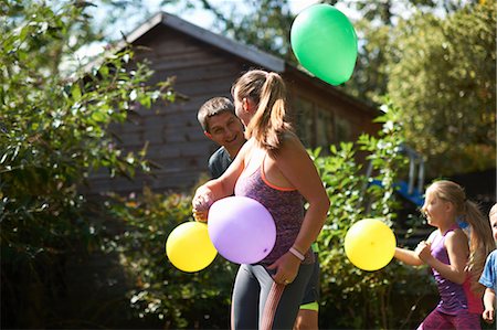simsearch:649-07436476,k - Family playing with balloons in garden Fotografie stock - Premium Royalty-Free, Codice: 649-09035547