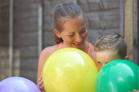 simsearch:649-07436476,k - Mother and son in garden, holding balloons Fotografie stock - Premium Royalty-Free, Codice: 649-09035549