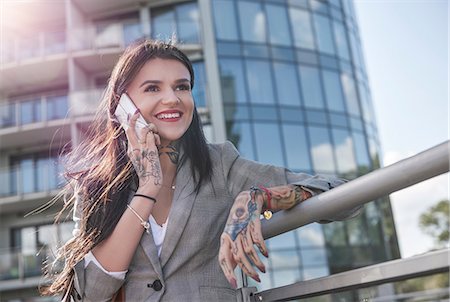 person smartphone tattoo - Businesswoman outdoors, using smartphone, smiling, tattoos on hands Stock Photo - Premium Royalty-Free, Code: 649-09035579