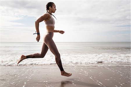 simsearch:649-08988270,k - Side view of young female runner running barefoot along water's edge at beach Foto de stock - Sin royalties Premium, Código: 649-09035631
