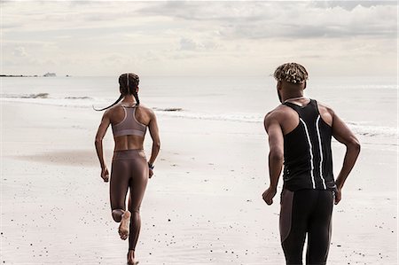 Rear view of young male and female runners running on beach Photographie de stock - Premium Libres de Droits, Code: 649-09035656
