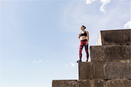Young female free runner looking out from top of sea wall Stock Photo - Premium Royalty-Free, Code: 649-09035777