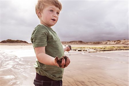 simsearch:649-06717318,k - Young boy on beach, holding wet sand, Santa Cruz de Tenerife, Canary Islands, Spain, Europe Foto de stock - Royalty Free Premium, Número: 649-09035921