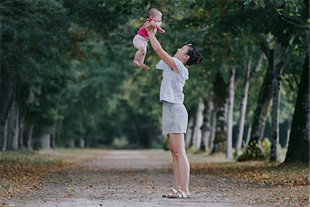 Woman holding up baby daughter in tree lined park, Chenonceaux, Loire Valley, France Photographie de stock - Premium Libres de Droits, Code: 649-09036036
