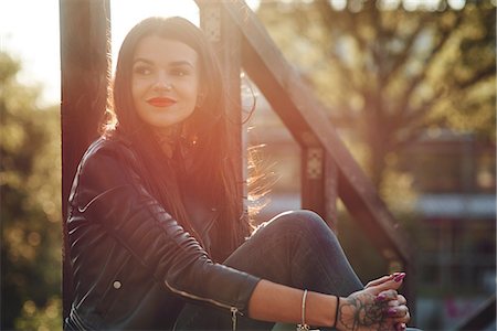 simsearch:649-09212515,k - Young woman relaxing outdoors, tattoos on hands Stock Photo - Premium Royalty-Free, Code: 649-09036114