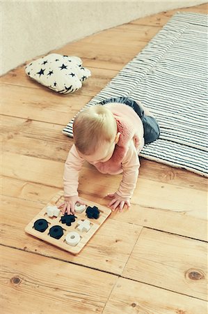simsearch:649-06829432,k - Baby girl playing with noughts and crosses on floorboards Stock Photo - Premium Royalty-Free, Code: 649-09036157