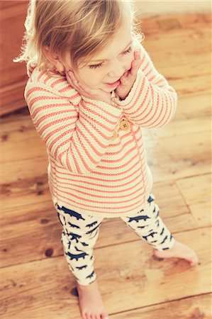 simsearch:649-06488477,k - High angle view of female toddler with hands on cheeks Photographie de stock - Premium Libres de Droits, Code: 649-09036173