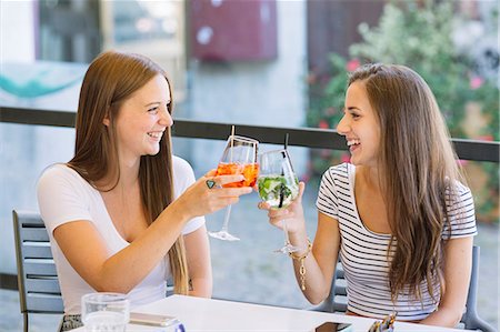 simsearch:649-08824511,k - Two young female friends raising a cocktail toast at sidewalk cafe Stock Photo - Premium Royalty-Free, Code: 649-09036308