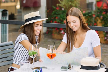 simsearch:649-08824511,k - Two young female friends looking at map at sidewalk cafe Stock Photo - Premium Royalty-Free, Code: 649-09036310