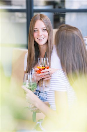 friend talking outdoors not children not bathing suit not school not beach not business - Two young female friends chatting over cocktails at sidewalk cafe Foto de stock - Sin royalties Premium, Código: 649-09036311