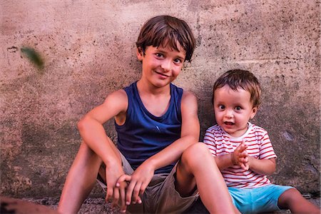 Portrait of boy and toddler brother sitting against wall Photographie de stock - Premium Libres de Droits, Code: 649-09036343