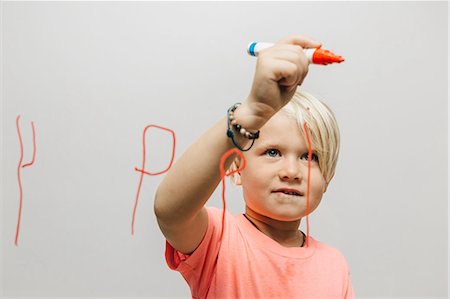 photography single boys person - Boy writing reversed letter P onto glass wall Stock Photo - Premium Royalty-Free, Code: 649-09036356