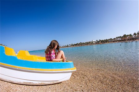 pedal boat - Girl sitting in a beached pedalo looking over her shoulder Stock Photo - Premium Royalty-Free, Code: 649-09036369