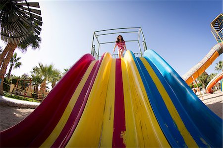 simsearch:649-07118498,k - Low angle view of girl preparing to slide on play park slide Photographie de stock - Premium Libres de Droits, Code: 649-09036373