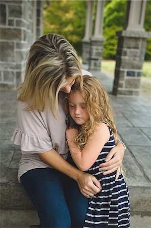 mother and daughter hugging sad