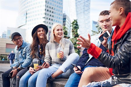 simsearch:614-09249701,k - Five young adult friends sitting on wall chatting in city Photographie de stock - Premium Libres de Droits, Code: 649-09061226