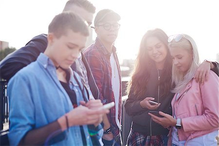 simsearch:649-09036191,k - Five young adult friends looking at smartphones in sunlit city Stock Photo - Premium Royalty-Free, Code: 649-09061237