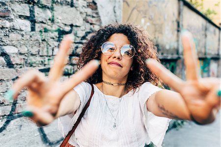 peace sign and woman - Woman making peace symbol, Milan, Italy Stock Photo - Premium Royalty-Free, Code: 649-09061259