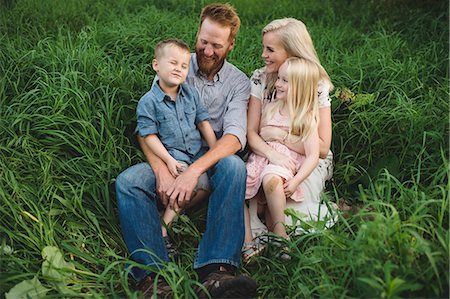 simsearch:649-08578037,k - Family sitting in tall grass together smiling Stock Photo - Premium Royalty-Free, Code: 649-09061313