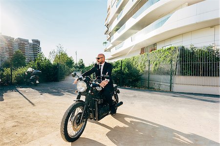 Portrait of mature businessman outdoors, sitting on motorcycle Stock Photo - Premium Royalty-Free, Code: 649-09061333