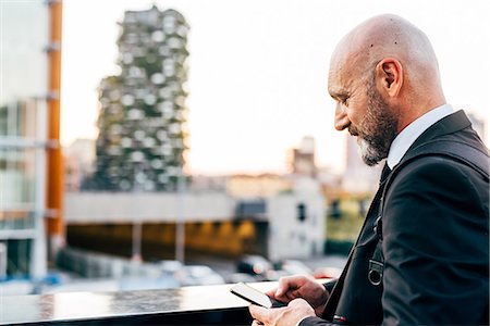 shaving (fragment) - Mature businessman standing outdoors, using smartphone Stock Photo - Premium Royalty-Free, Code: 649-09061350