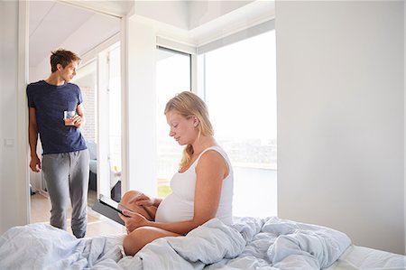 simsearch:649-09061407,k - Pregnant young woman cross legged on bed using digital tablet Photographie de stock - Premium Libres de Droits, Code: 649-09061395