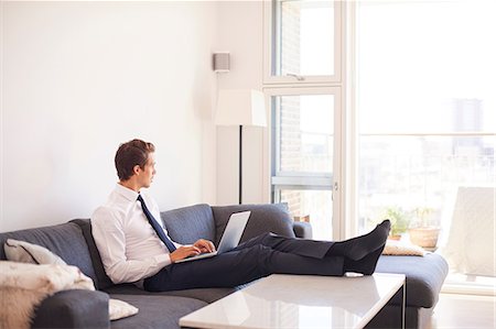 simsearch:649-09061407,k - Businessman sitting on sofa using laptop Photographie de stock - Premium Libres de Droits, Code: 649-09061444