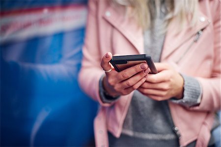 Mid section of young woman holding smartphone at city tram station Photographie de stock - Premium Libres de Droits, Code: 649-09061453