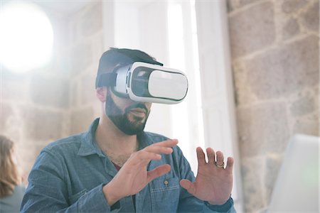 surreal - Businessman wearing virtual reality headset in office Stock Photo - Premium Royalty-Free, Code: 649-09061463