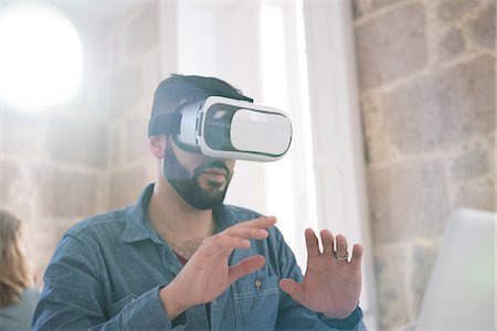 surrealistic - Businessman wearing virtual reality headset in office Stock Photo - Premium Royalty-Free, Code: 649-09061463