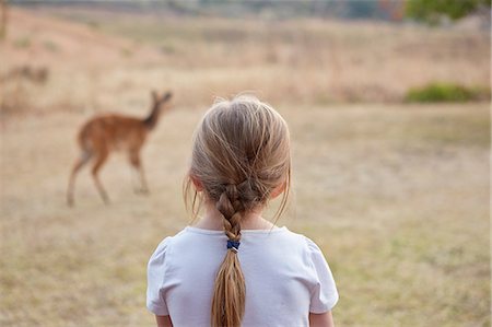 simsearch:649-06489102,k - Girl in rural setting, watching mountain reedbuck antelope, rear view Fotografie stock - Premium Royalty-Free, Codice: 649-09061471