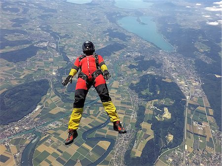 sport woman with helmet - Female skydiver free falling on back above landscape Stock Photo - Premium Royalty-Free, Code: 649-09061484