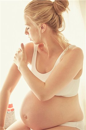 pregnant crop tops - Pregnant woman applying moisturizer Stock Photo - Premium Royalty-Free, Code: 649-09061570