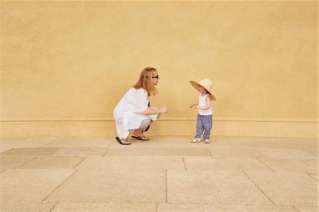 simsearch:614-08880953,k - Pregnant woman and daughter playing by yellow wall Photographie de stock - Premium Libres de Droits, Code: 649-09061573