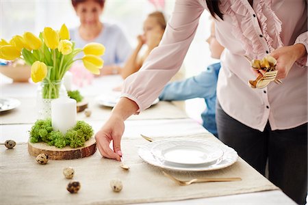 Woman and family preparing place settings at easter dining table Stockbilder - Premium RF Lizenzfrei, Bildnummer: 649-09061685
