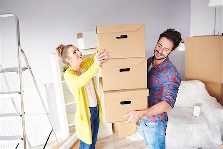 simsearch:614-01170983,k - Young couple moving home, young man holding stack of cardboard boxes Photographie de stock - Premium Libres de Droits, Code: 649-09061731