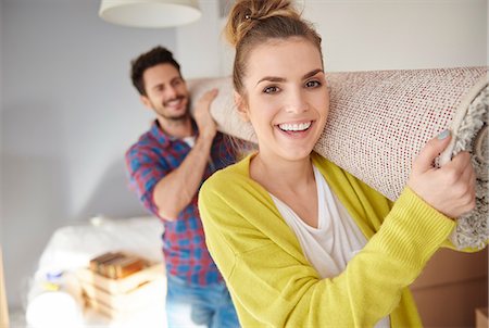 person rolled inside a rug - Young couple moving home, carrying rolled tug on shoulders, smiling Stock Photo - Premium Royalty-Free, Code: 649-09061733