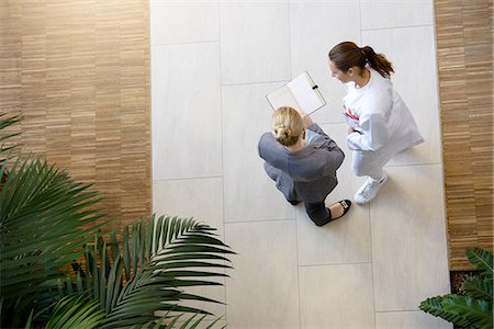 female doctor full body - Female doctor and young woman, looking at book, elevated view Stock Photo - Premium Royalty-Free, Code: 649-09061774