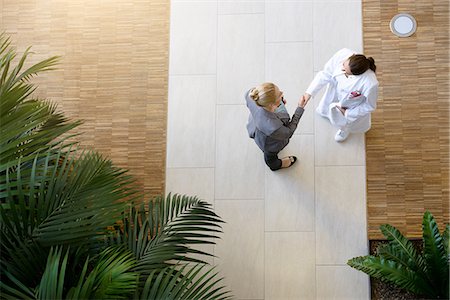 doctor shaking hands full body - Female doctor and young woman, shaking hands, elevated view Stock Photo - Premium Royalty-Free, Code: 649-09061773