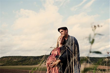 Portrait of happy pregnant mid adult couple in fields Foto de stock - Sin royalties Premium, Código: 649-09061899