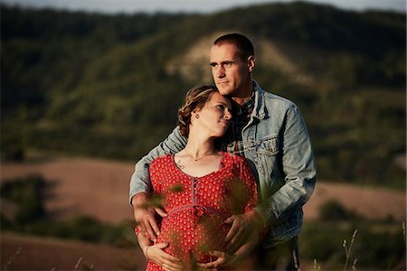 Romantic man with hands on pregnant wife's stomach in landscape Foto de stock - Royalty Free Premium, Número: 649-09061905