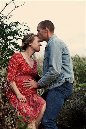 Romantic man kissing pregnant wife's forehead on tree trunk Photographie de stock - Premium Libres de Droits, Code: 649-09061909