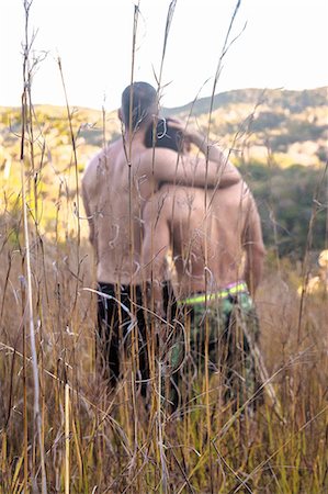 Rear view of two bare chested men looking out at landscape from long grass, Guaramiranga, Ceara, Brazil Photographie de stock - Premium Libres de Droits, Code: 649-09077928
