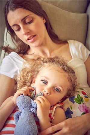 simsearch:649-08085998,k - Pregnant woman and daughter reclining on sofa with soft toy Photographie de stock - Premium Libres de Droits, Code: 649-09077934