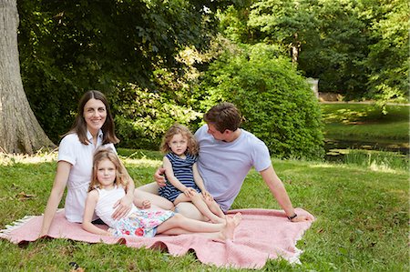 Portrait of mid adult parents and two daughters on picnic blanket in park Stock Photo - Premium Royalty-Free, Code: 649-09077960