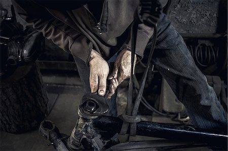 suéters - Mechanic repairing dismantled vintage motorcycle in workshop, mid section Foto de stock - Sin royalties Premium, Código: 649-09077980