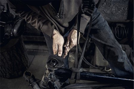 Mechanic repairing dismantled vintage motorcycle in workshop, mid section Stock Photo - Premium Royalty-Free, Code: 649-09077980